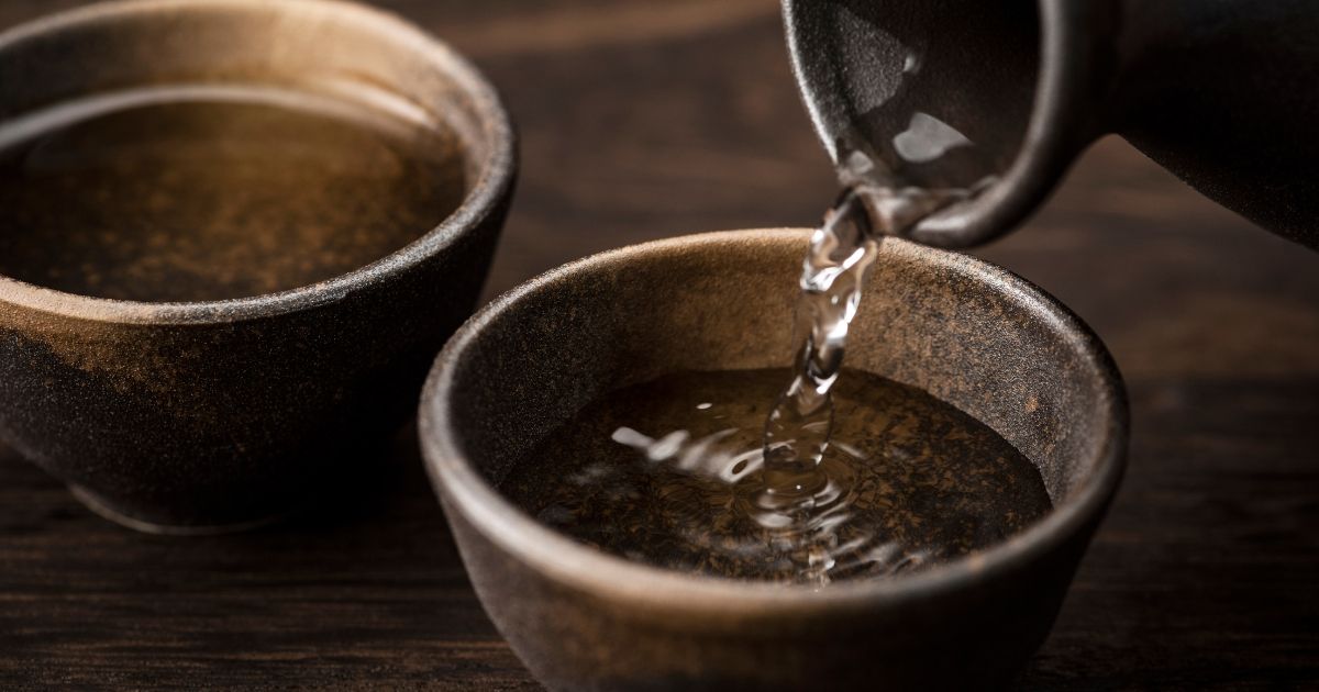 Brown sake bottle pouring sake to a small bowl