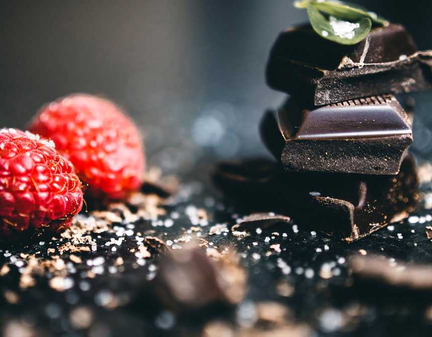 Dark chocolate near raspberries