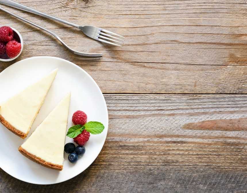 Two slices of New York cheesecake on a table