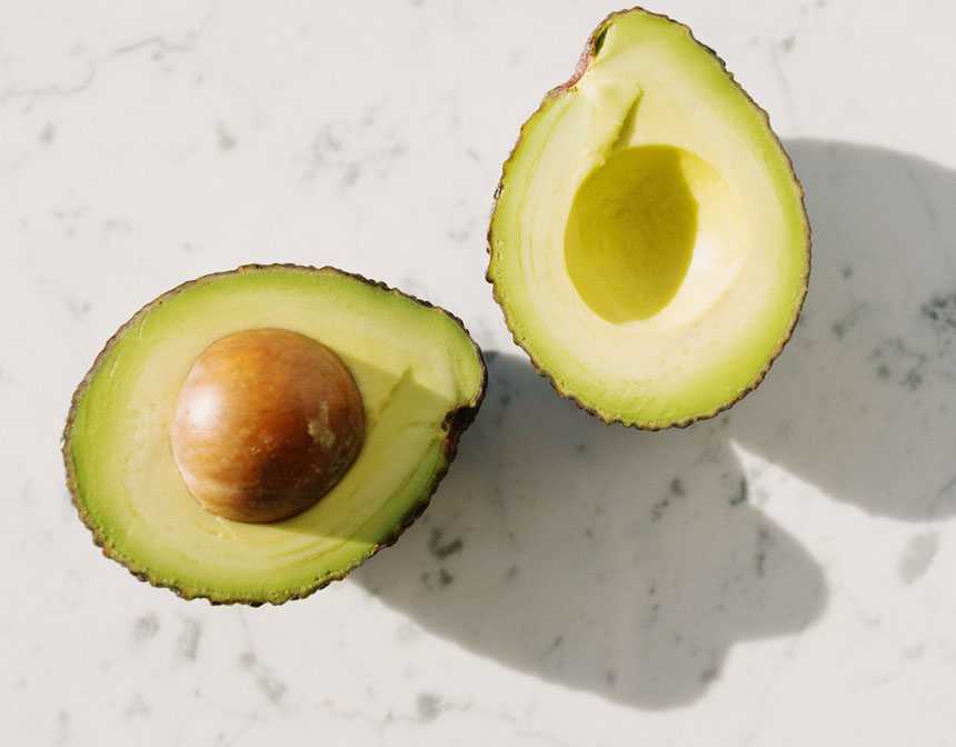 Sliced avocado fruit on white surface